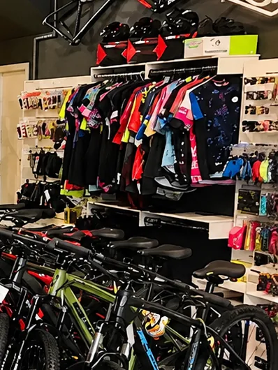 Arara com camisas de ciclismo coloridas e capacetes na prateleira